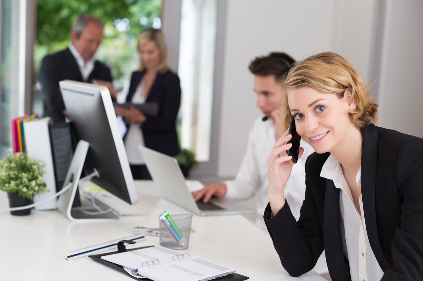 Woman on phone in office setting enrolling online